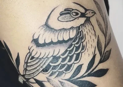 Tatouage d'un oiseau sur une branche de laurier. Dotwork tattoo