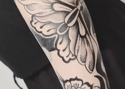 Tatouage en noir d'un papillon et dotwork. Ornemental floral, lignes noires et epaisses