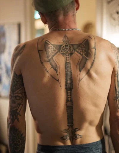 Tatouage dans le dos, représentant une hache