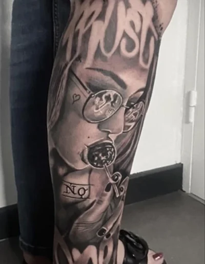Tatouage réaliste d'un visage de femme avec des lunettes et une sucette