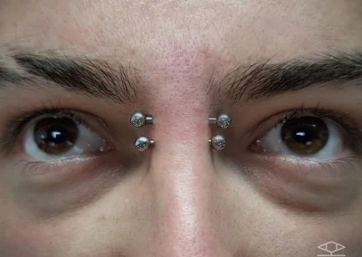 Homme avec un double piercing sur le bridge