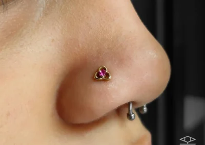 Femme avec un bijoux de piercing sur la narine et un bijou de piercing en forme de fer à cheval au niveau du septum