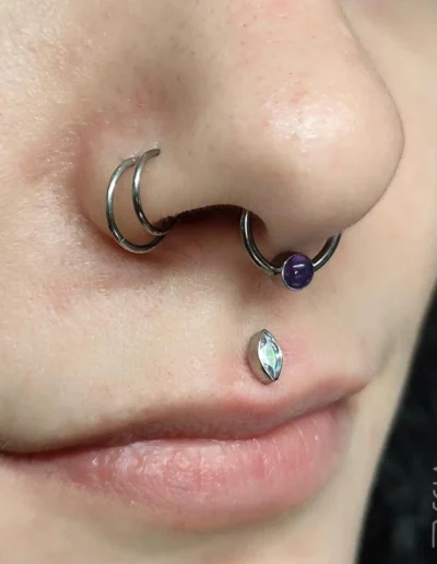 Femme avec un double piercing sur la narine, ainsi qu'un medusa et un bijou de piercing au septum