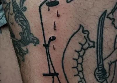 Tatouage en fineline d'un flexible de douche