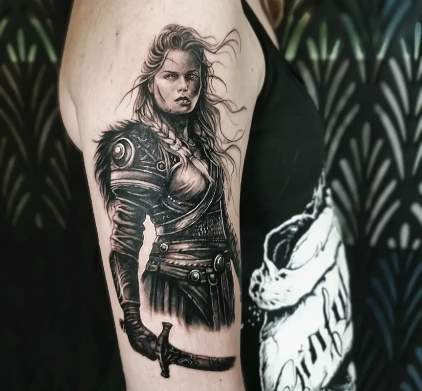 Tatouage femme guerrière Tatouage femme guerrière ou valkyrie avec épée, style réaliste en noir et gris sur le bras