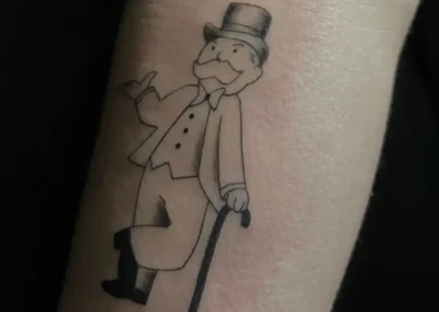 Tatouage de Monsieur Monopoly (Rich Uncle Pennybags) en noir et gris, avec son chapeau haut-de-forme et sa canne