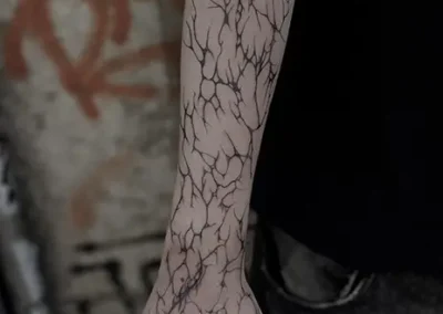 Tatouage de lignes en style néo tribal sur le bras et la main