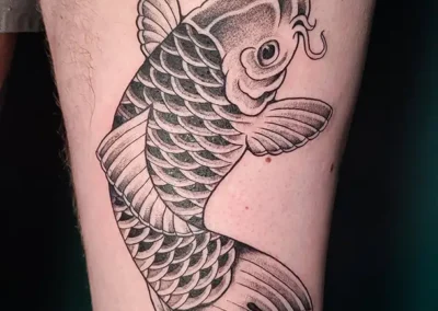 Grand tatouage carpe koï monochrome sur la cuisse, style artistique japonais