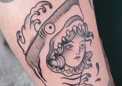 Tatouage créatif femme-requin en noir et blanc, style traditionnel, avec des vagues
