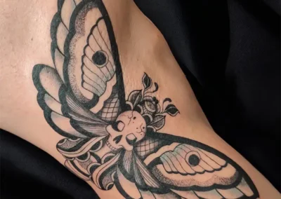 Tatouage grand papillon de nuit avec tête de mort stylisée, noir et gris