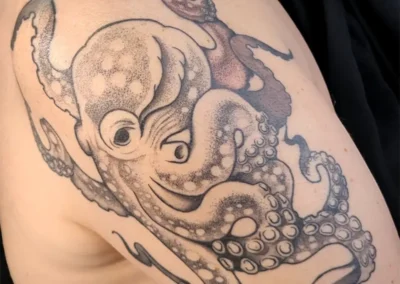 Tatouage d'une pieuvre en noir et blanc, sur l'épaule
