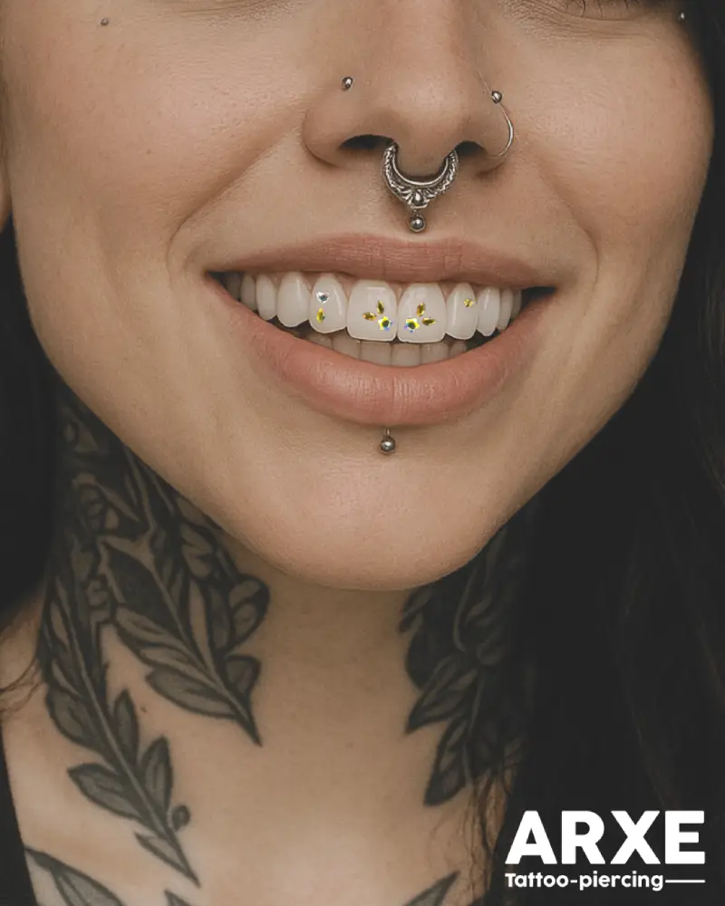 pose-strass-dentaire-1 Jeune femme souriante percée à la lèvre et au nez, portant un strass dentaire