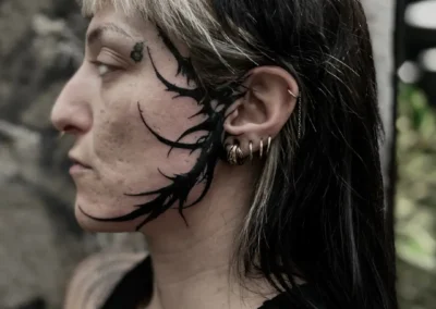 Tatouage visage de style cybersigilism aux lignes noires organiques et acérées