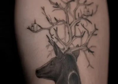 Tatouage d'une biche ornée de branches
