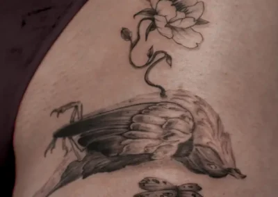 Tatouage d'un oiseau mort avec une fleur