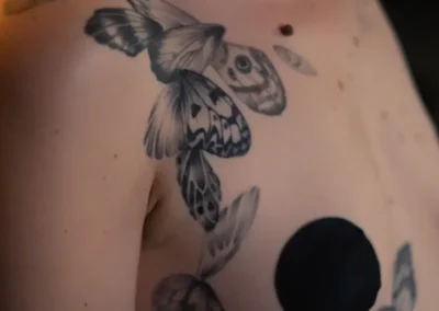 Tatouage de plumes et ailes sur l'épaule
