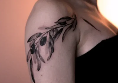 Tatouage d'une branche d'olivier et d'olives sur l'épaule