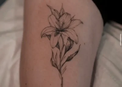 Tatouage d'une fleur sur la cuisse